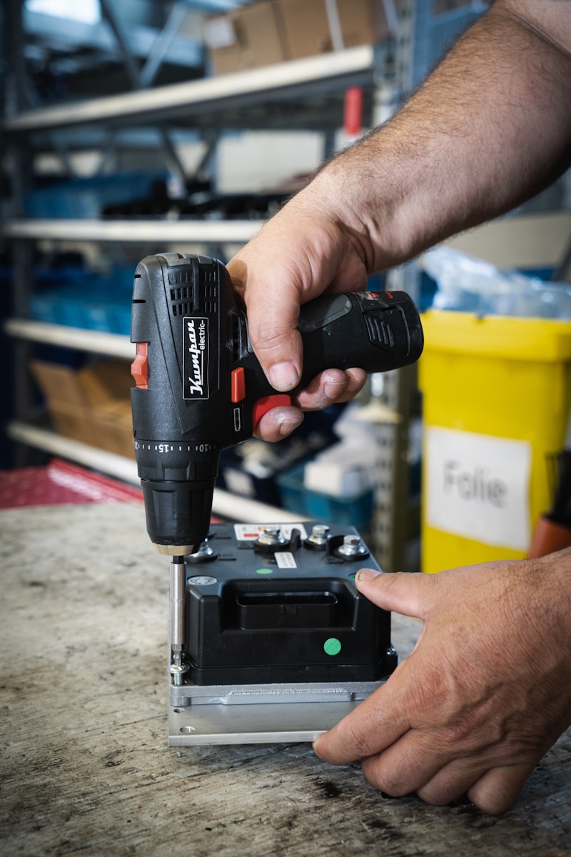a man using a drill gun on a piece of metal
